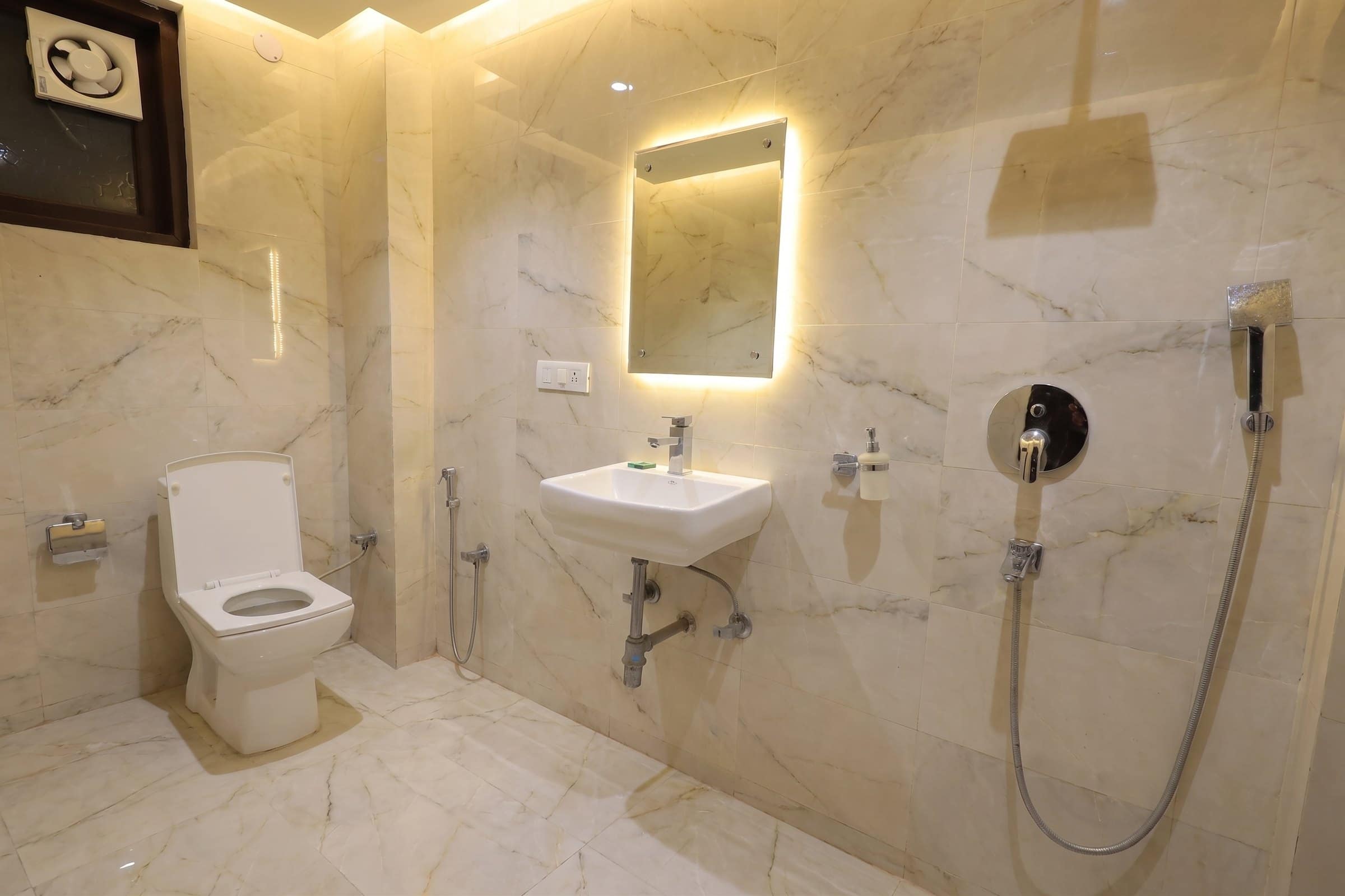 A bathroom with a lit mirror