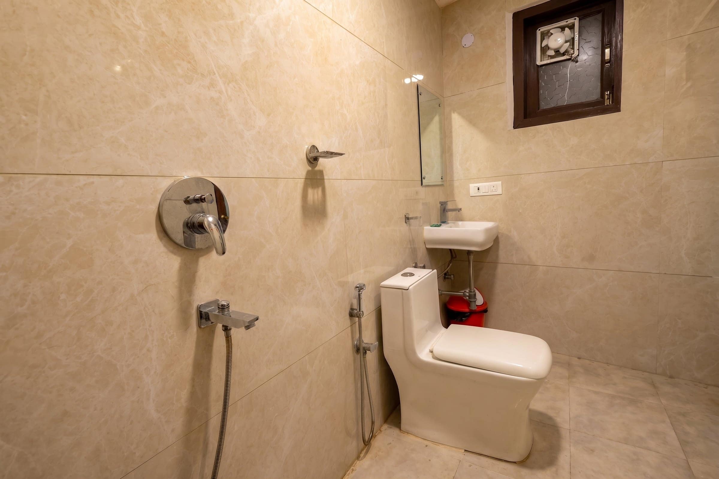 A marble-tiled attached bathroom