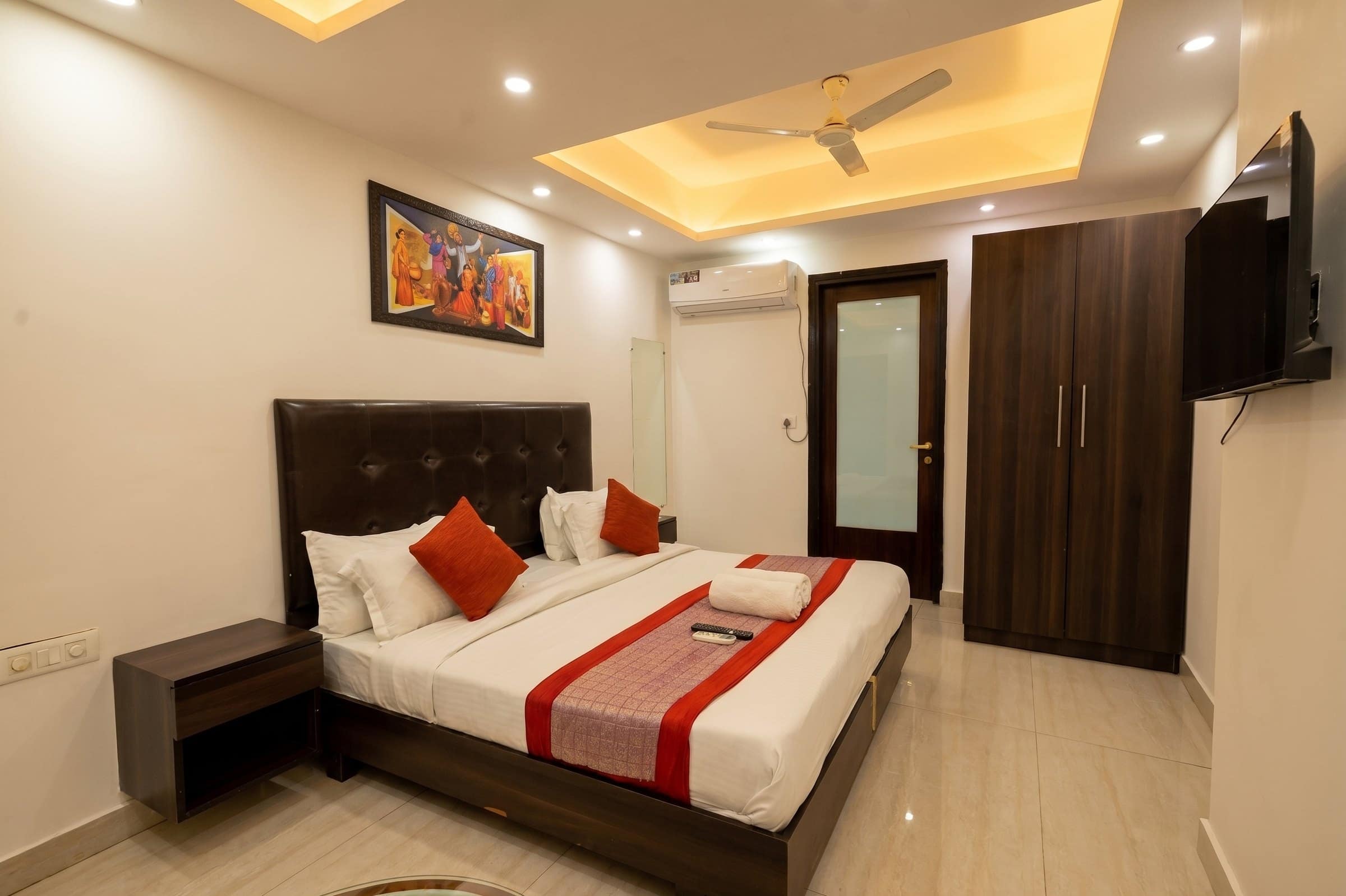 A Deluxe room: bed, wardrobe and wall-mounted TV, with no external window
