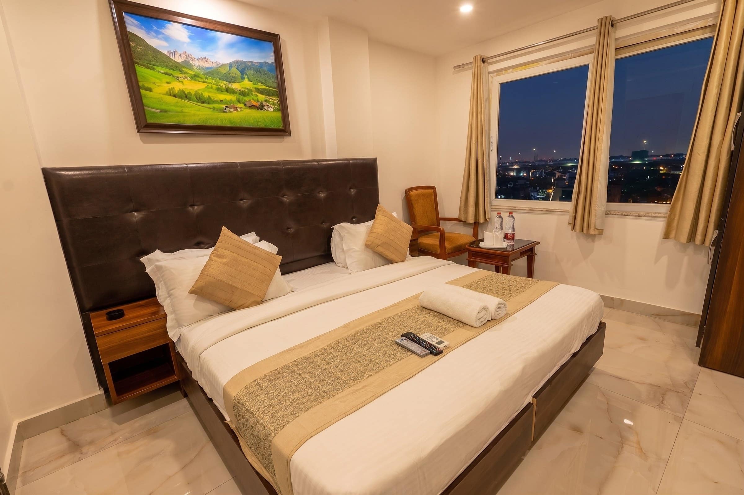 A room at Taj Home Stay at dusk, the lights of Dwarka through the window